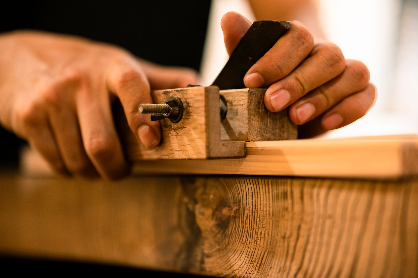 A craftsman planing solid walnut by hand